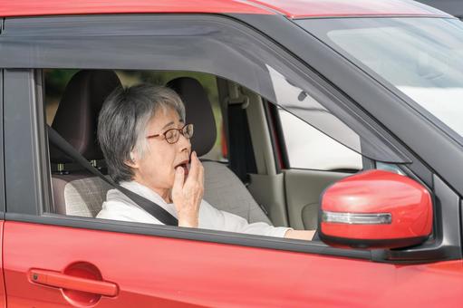 自動車の運転中にあくびをする高齢者女性 運転,あくび,高齢者の写真素材