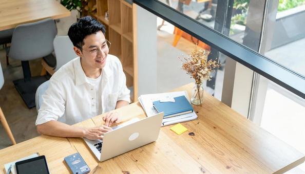 カフェで仕事をするフリーランス男性 カフェで仕事をするフリーランス男性の写真