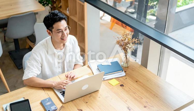カフェで仕事をするフリーランス男性 男性,コワーキングスペース,コワーキングの写真素材
