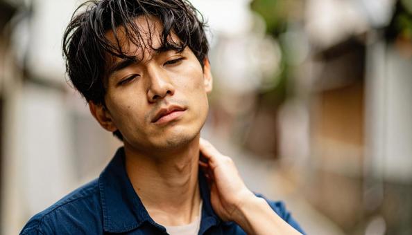 寝違えて首痛に苦しむ男性の写真