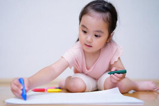 床に座って画用紙にお絵描きする子供 女の子,お絵描き,真剣の写真素材