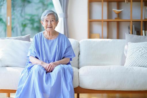 穏やかに微笑むソファの高齢女性 女性,ソファ,座るの写真素材