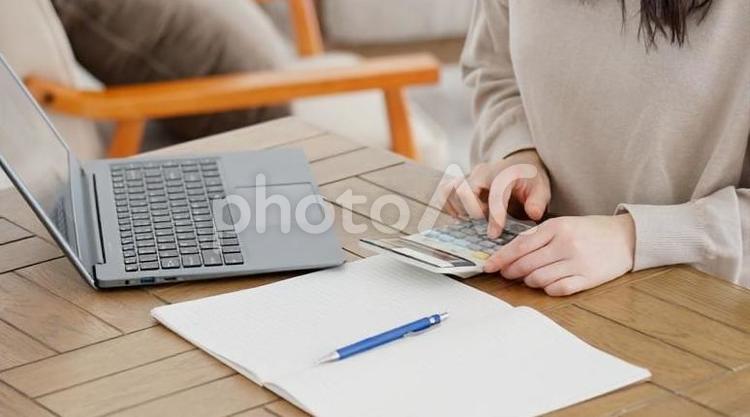 費用を電卓で計算する女性 女性,電卓,費用の写真素材
