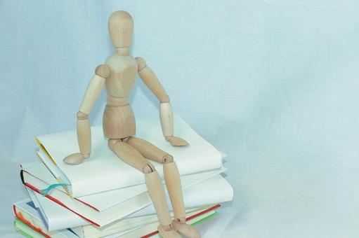 重ねた本に座る人形 重ねた本に座る人形 本,読書,本好きの写真素材