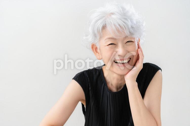 白バックでスキンケアをするシニアの女性 ビューティー,女性,シニアの写真素材
