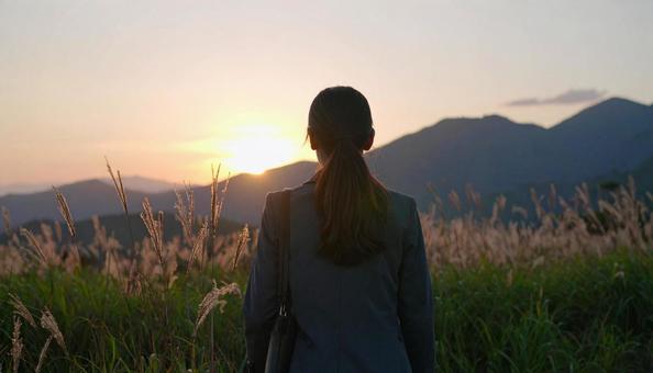 夕焼けに手を合わせて祈る女性 夕焼けに手を合わせて祈る女性の写真