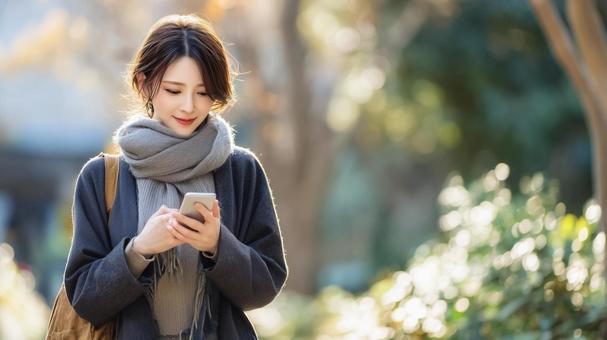 スマホを操作する女性 スマホを操作する女性の写真