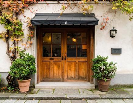 温かみのある木の扉と植木鉢の写真