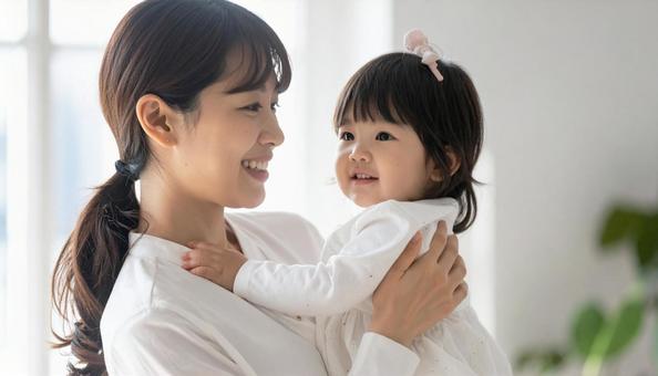 女の子を抱っこしてあやす母親 女の子を抱っこしてあやす母親の写真