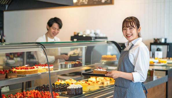 ケーキを陳列しているアルバイトをする女性 ケーキを陳列しているアルバイトをする女性の写真