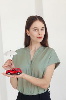 車の模型を持った女性 保険業,事務職,接客業の写真素材