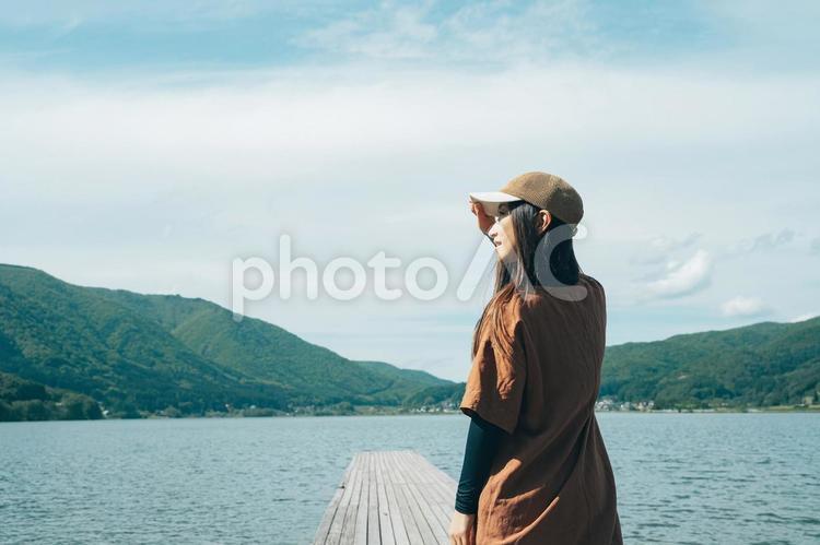 湖の桟橋に立つ女性キャンパーの横顔 キャンプ,湖,女性の写真素材