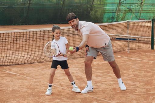 ボールを使ってフォームを指導する男性 親子,女の子,男性の写真素材