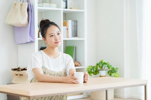 リビングでくつろぐ若い女性 リビングでくつろぐ若い女性 女性,家,笑顔の写真素材