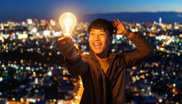 電球と共にひらめく若手クリエイター 電球と共にひらめく若手クリエイターの写真