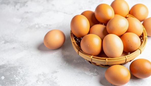 竹の籠に入った新鮮な卵の写真