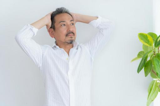 リビングでヘアケアをするミドルの男性 リビングでヘアケアをするミドルの男性 ヘアケア,育毛,ヘアセットの写真素材