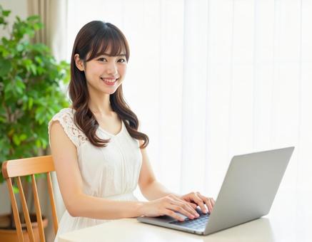 ノートパソコンを使う若い女性 ノートパソコンを使う若い女性の写真