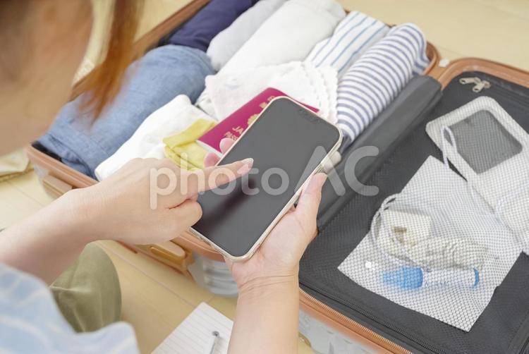 スマホで旅行の準備のチェックをする女性 女性,40代,30代の写真素材