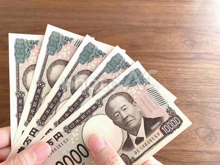 机上で5万円を持つ女性の手 5万円,お金,持つの写真素材