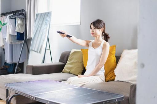 家でテレビを見る若い女性 家でテレビを見る若い女性 女性,リビング,くつろぐの写真素材