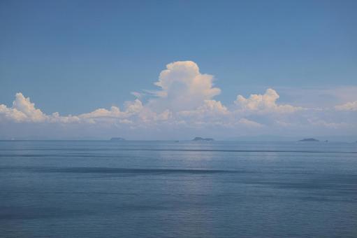 青空と白い雲と島と船と青い海面の海の風景 青空と白い雲と島と船と青い海面の海の風景の写真