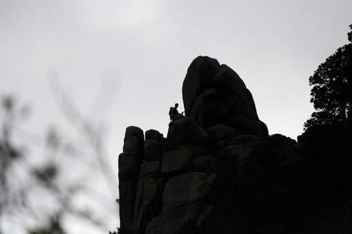 絶壁に上の人 絶壁,岩山,人影の写真素材
