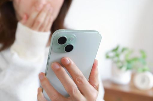 スマートフォンを見て驚く女性 スマートフォン,女性,スマホの写真素材