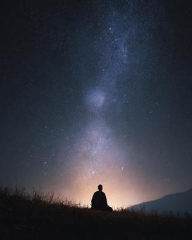 満天の星空の下、瞑想する僧侶 満天の星空の下、瞑想する僧侶の写真