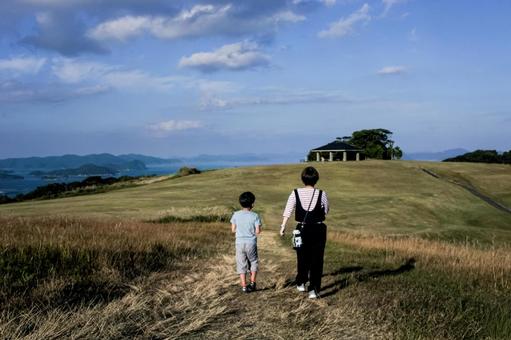 ＜素材＞山頂を散歩する家族の後ろ姿 家族,空,ウォーキングの写真素材