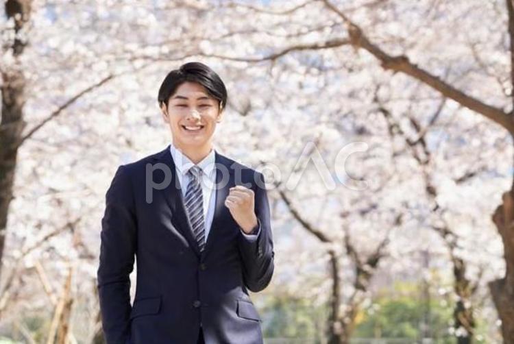 桜を背景にガッツポーズをするビジネスマン ビジネスマン,男性,笑顔の写真素材