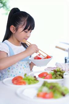 トマトとレタスを盛り付ける食卓の風景 女の子,トマト,野菜の写真素材