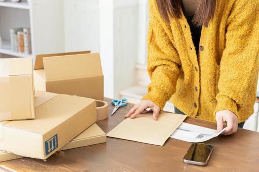 荷造りする女性の手元 荷造りする女性の手元 段ボール,荷造り,ガムテープの写真素材