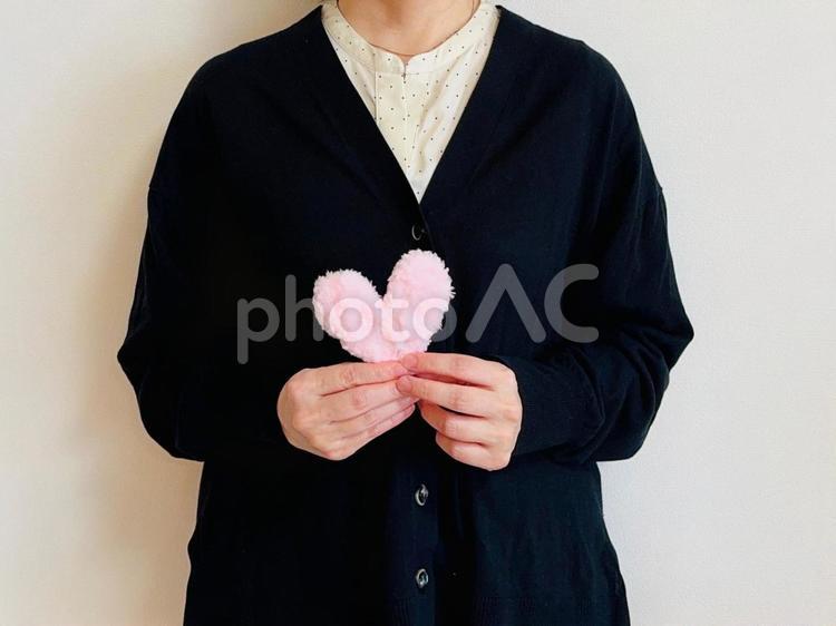 ピンクのハートを持つ女性（黒トップス） ハート,女性,上半身の写真素材