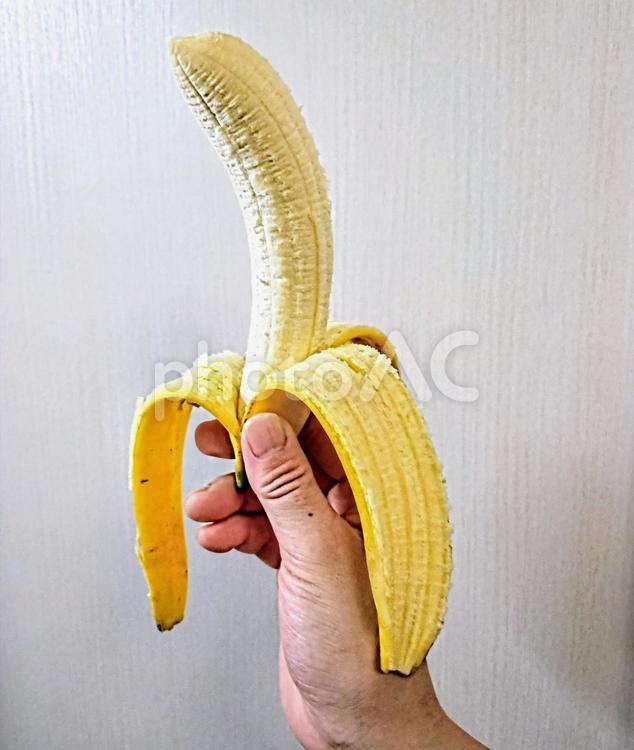 右手に川を剥いたバナナを持つ　果物 バナナ,果物,果糖の写真素材
