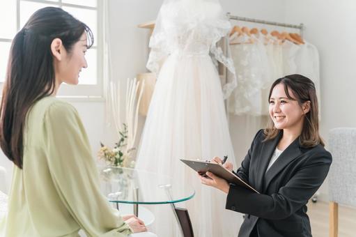 衣装合わせするウェディングプランナー 衣装合わせするウェディングプランナー ドレスショップ,ドレス,ウェディングドレスの写真素材