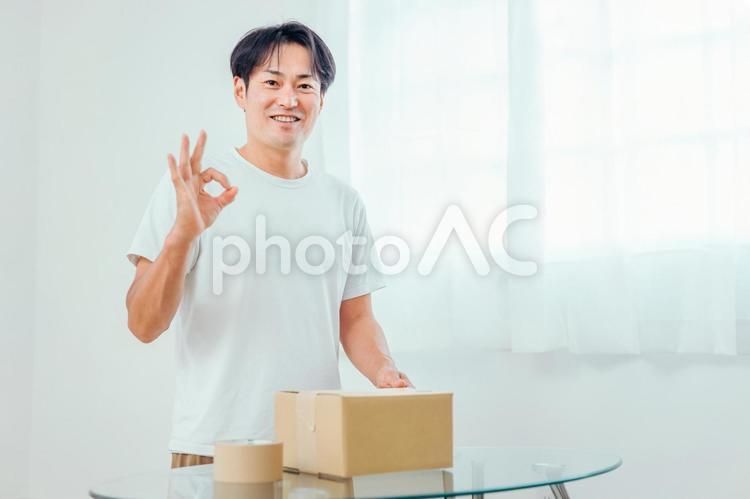 段ボールを開ける男性（笑顔） 荷造り,宅急便,宅配便の写真素材