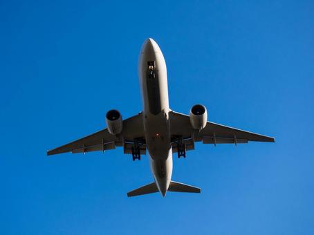 青空の下、車輪を出し着陸態勢に入る航空機 航空機,ジェット機,飛行機の写真素材