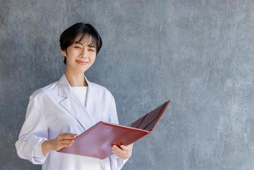 説明をする白衣の若い女性 説明をする白衣の若い女性 女性,全身,白衣の写真素材