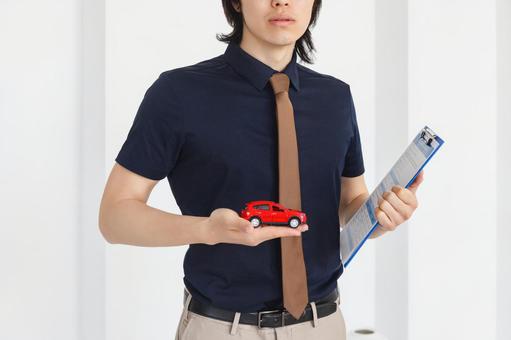 赤い車を手のひらに持った男性スタッフ 保険業,事務職,接客業の写真素材