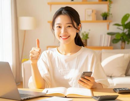 家計がうまくいきスマホ片手に微笑む女性 家計がうまくいきスマホ片手に微笑む女性の写真