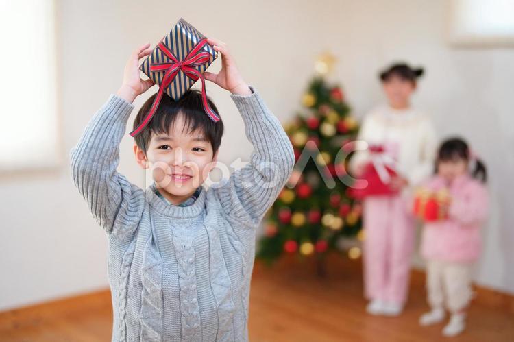 頭の上でプレゼントを持つ男の子 男の子,横目,クリスマスの写真素材