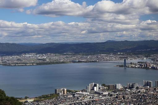 琵琶湖と市街地と山並みと雲と青空の風景 琵琶湖と市街地と山並みと雲と青空の風景 琵琶湖,市街地,山並みの写真素材