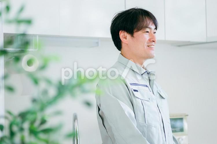 キッチンと作業着姿の男性 工務店,作業服,設備の写真素材