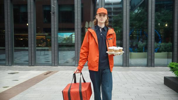 保温ピザバッグとドリンクを持って歩くフードデリバリーの男性 配達,デリバリー,配送の写真素材