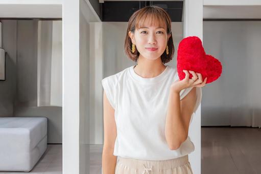 ハートを出す女性 ハートを出す女性 女性,笑顔,白い服の写真素材