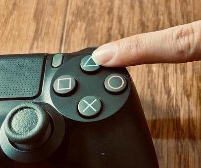 コントローラーの三角ボタンを押す コントローラーの三角ボタンを押す ゲーム機,コントローラー,リモコンの写真素材