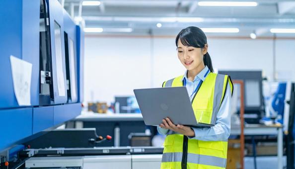 工場の三次元測定機を使う作業服の女性 工場の三次元測定機を使う作業服の女性の写真