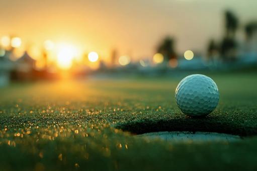 夕日が輝くゴルフコースのボールとホール 夕日が輝くゴルフコースのボールとホールの写真