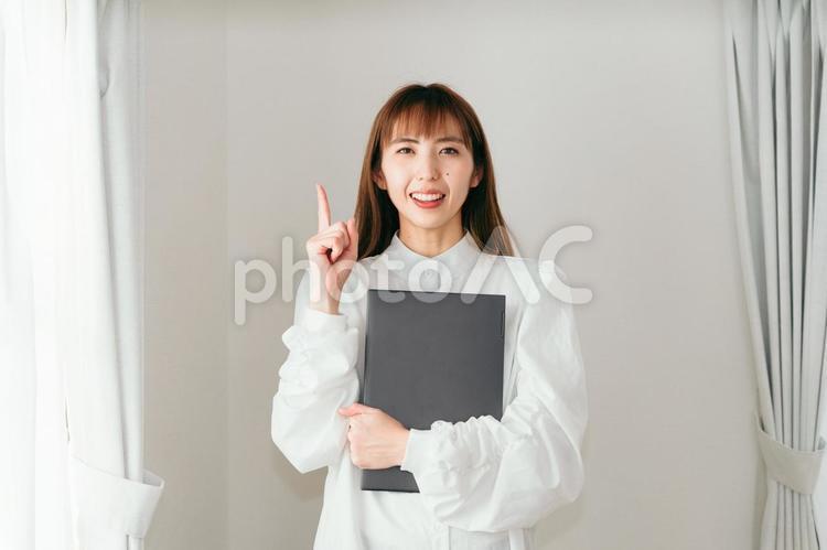 ノートパソコンを持って指をさす女性 ライフスタイル,リラックス,おしゃれの写真素材